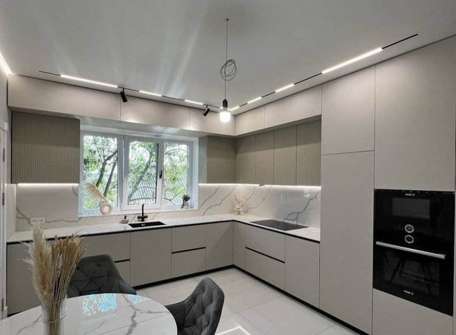 Светло-серая угловая кухня с антресолями в потолок и окном для частного дома №20